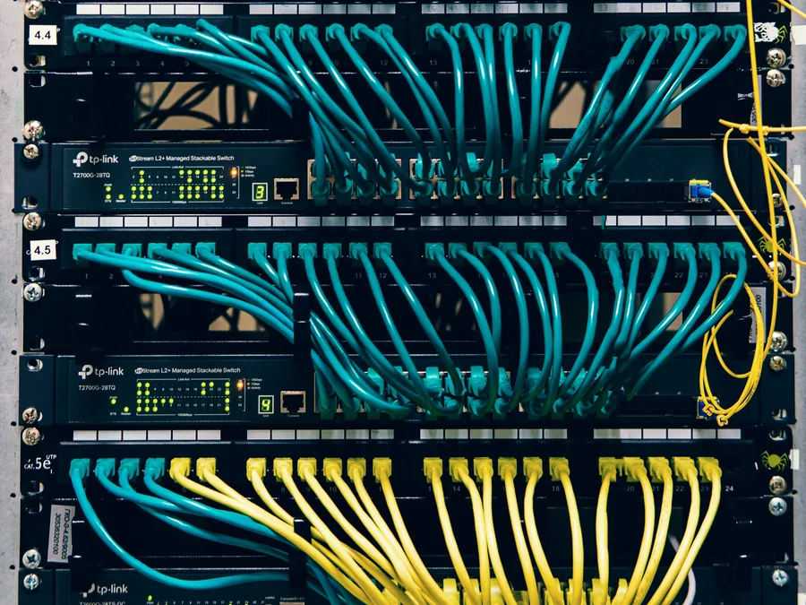 Bastidor de rede com cabos de dados ligados aos switches